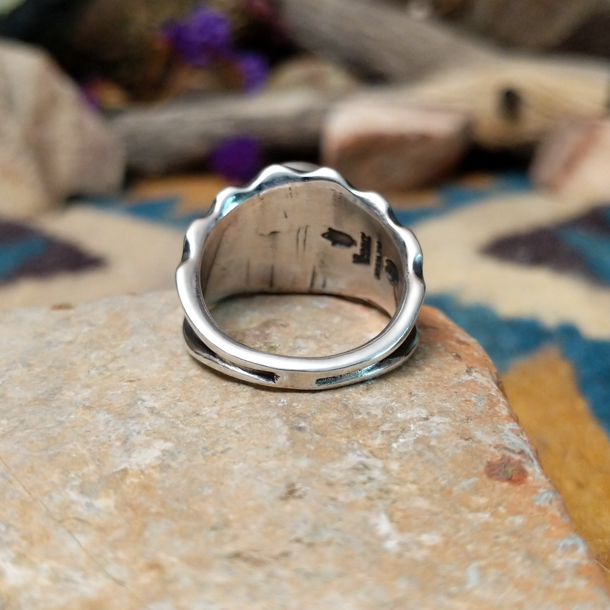 Sterling silver Red Spiny Oyster Shell ring by Raymond Coriz with an oval red and orange gemstone in a sunburst design; underside view.