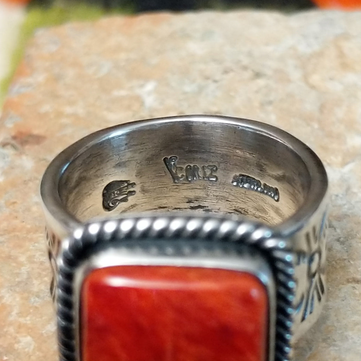 Red Spiny Oyster Shell Ring by Raymond Coriz with a square red-orange cabochon, twisted rope-style sterling silver border, and stamped silver band; artisan and Sterling Silver stamp.