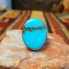 Redskin Turquoise Ring by Everett & Mary Teller featuring a large oval sky-blue turquoise stone with distinctive brown spiderweb matrix, a smooth polished surface, and a simple silver bezel setting.