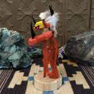 Navajo-made redtail hawk kachina doll by M. C. in red with raised leg, yellow beak, and fur collar.