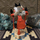 Navajo-made redtail hawk kachina doll by M. C. in red with raised leg, yellow beak, and fur collar.