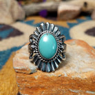 Sterling silver turquoise ring by Raymond Coriz featuring an oval turquoise cabochon, twisted rope bezel, concho-inspired fan design, and intricate Southwestern silverwork.