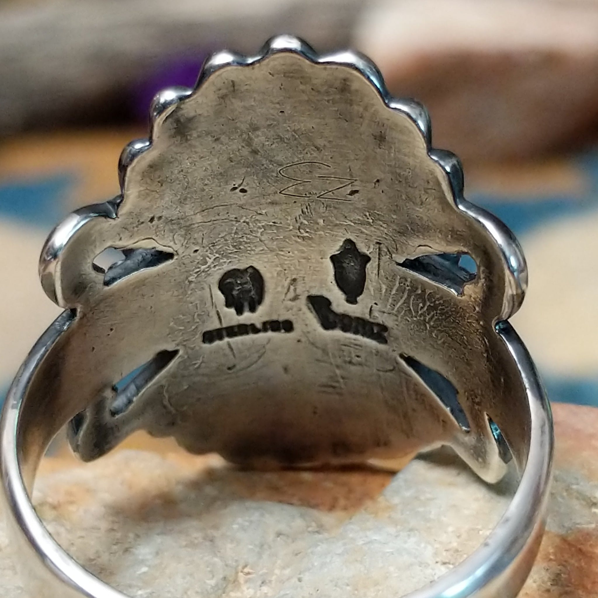 Sterling silver turquoise ring by Raymond Coriz featuring an oval turquoise cabochon, twisted rope bezel, concho-inspired fan design, and intricate Southwestern silverwork; artisan and Sterling Silver stamp.