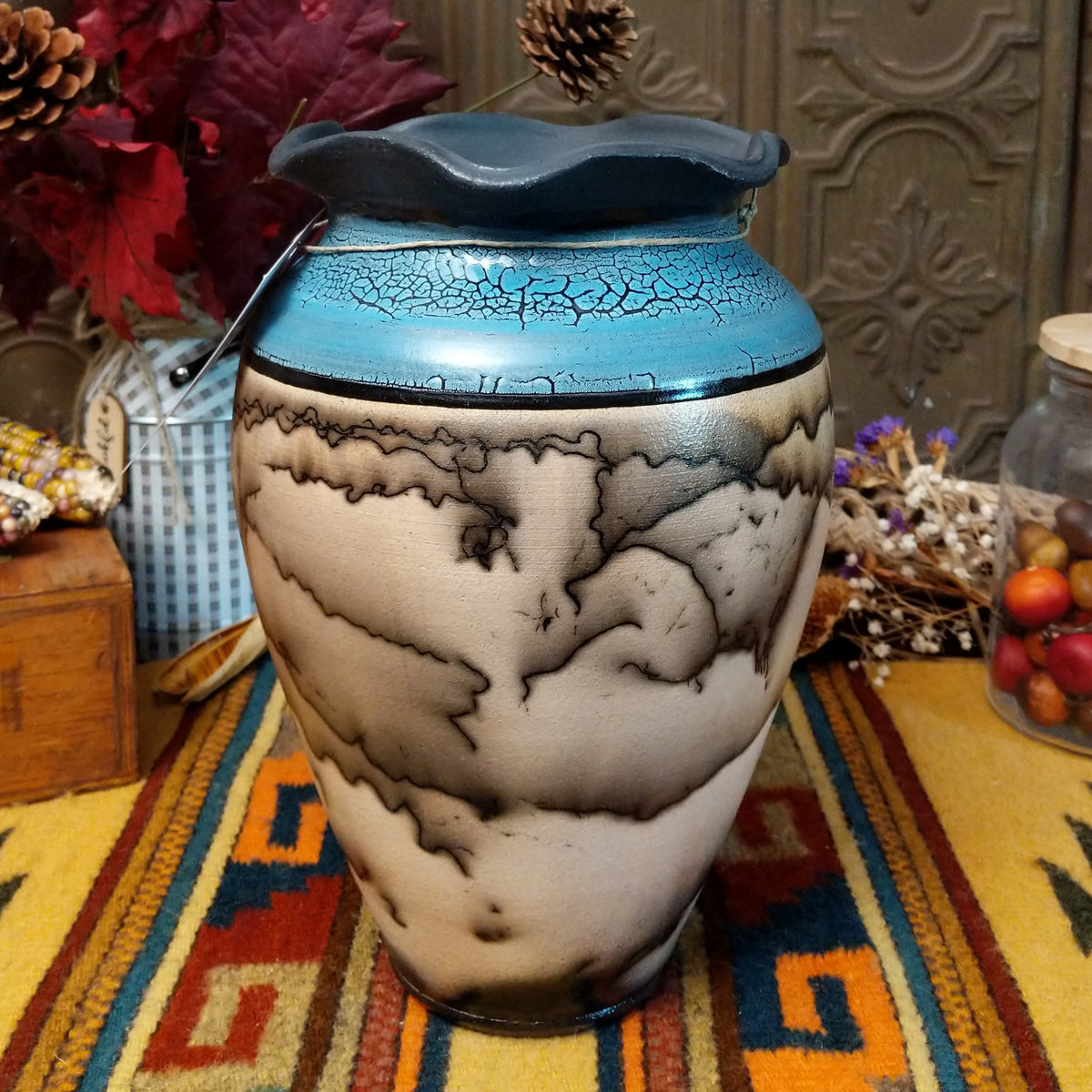 Horsehair pottery vase by Roger Calhoun with a rippled dark rim, metallic blue crackled upper section, and branching black horsehair patterns across a cream-colored body.