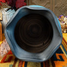 Horsehair pottery vase by Roger Calhoun with a rippled dark rim, metallic blue crackled upper section, and branching black horsehair patterns across a cream-colored body.