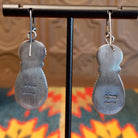 Pair of matching Sonoran Gold earrings on a stand with the back side showing with artisan hallmark. 