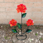 An orange rose bouquet metal art piece featuring three vibrant roses with green leaves.
