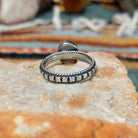 Sterling silver ring by Elgin Tom featuring an oval Golden Hills turquoise stone with natural matrix and a detailed silver band; underside view.