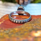 Sterling silver ring with patterned band, twisted rope accents, and malachite set in the round bezel.