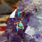 14kt gold round multistone inlay pendant by Selena Warner with geometric mosaic design and tapered gold bail.