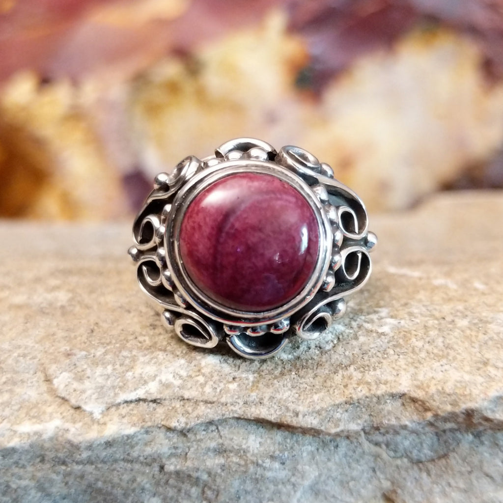 Purple spiny oyster shell in the scrolled silver setting of the ring.
