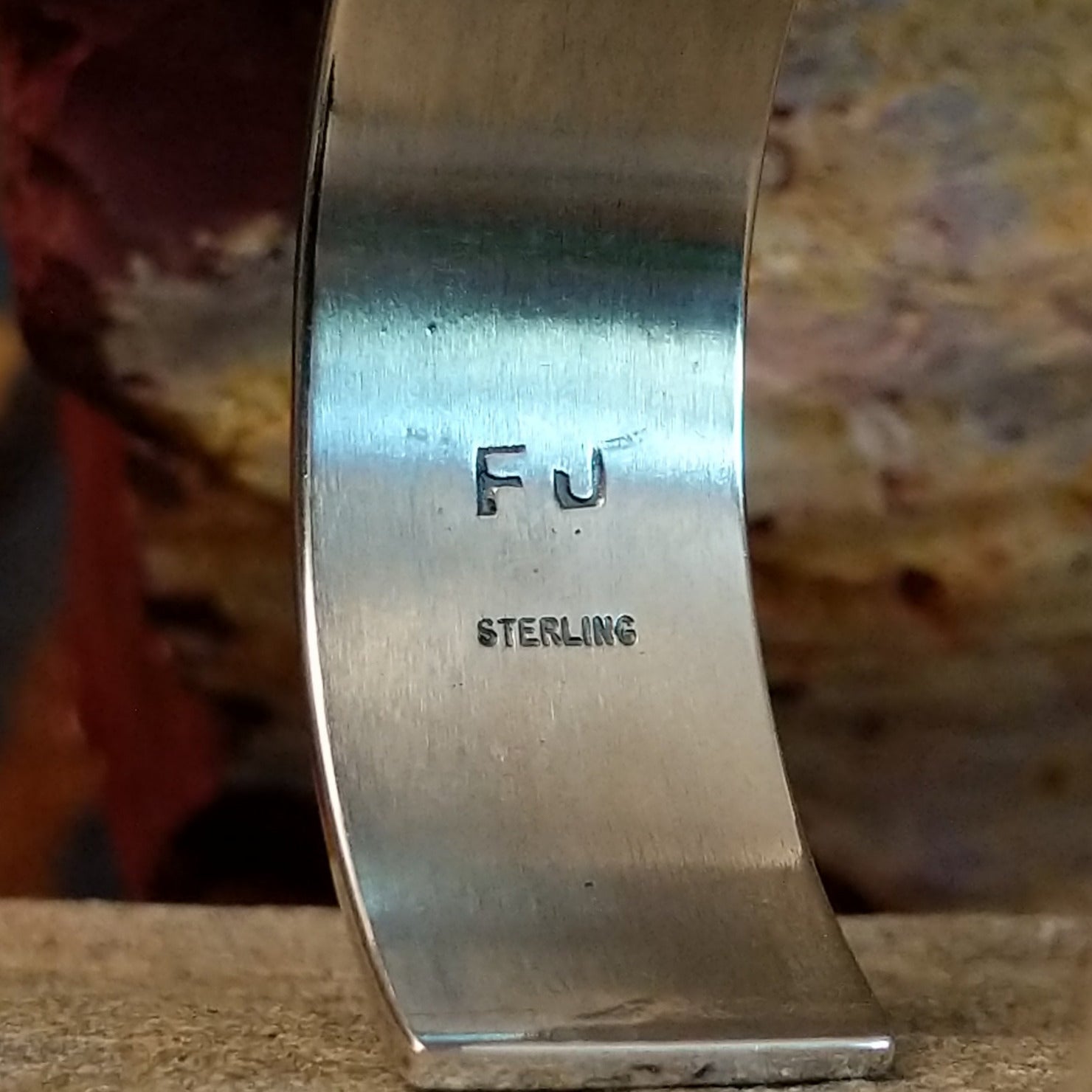The underside of the cuff showcases the artist's stamp.