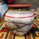 Round horsehair pottery vase by Roger Calhoun with a wide red rim, gold and lavender crackled shoulder, red accent band, and smoky black horsehair markings across a cream-colored body.