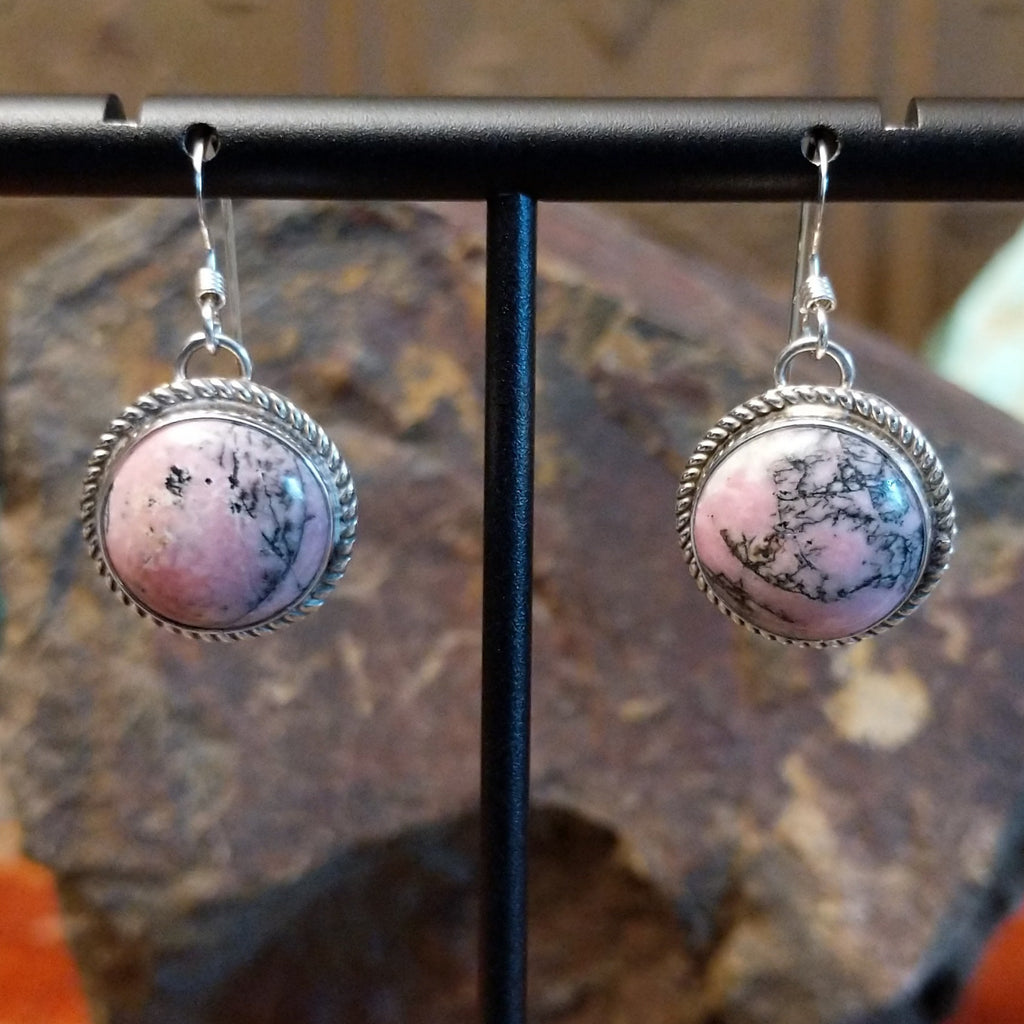 Round rhodochrosite earrings set within twisted rope bezels featuring dark matrix within the stone.