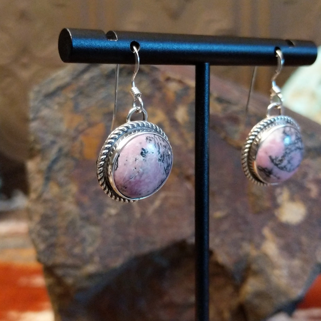 Round rhodochrosite earrings set within twisted rope bezels featuring dark matrix within the stone.