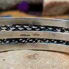 Handcrafted sterling silver cuff by H.R.M. featuring a round Sonoran Gold turquoise cabochon centered between polished silver bands with dual oxidized chain accents; artisan and Sterling Silver stamp.