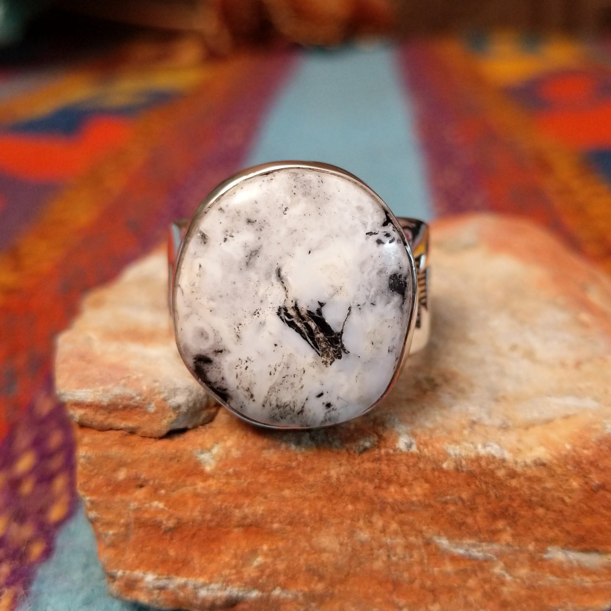 Round White Buffalo Ring by L.P. featuring a large creamy white cabochon with natural black and gray matrix, set in a smooth silver bezel with a substantial detailed silver band.