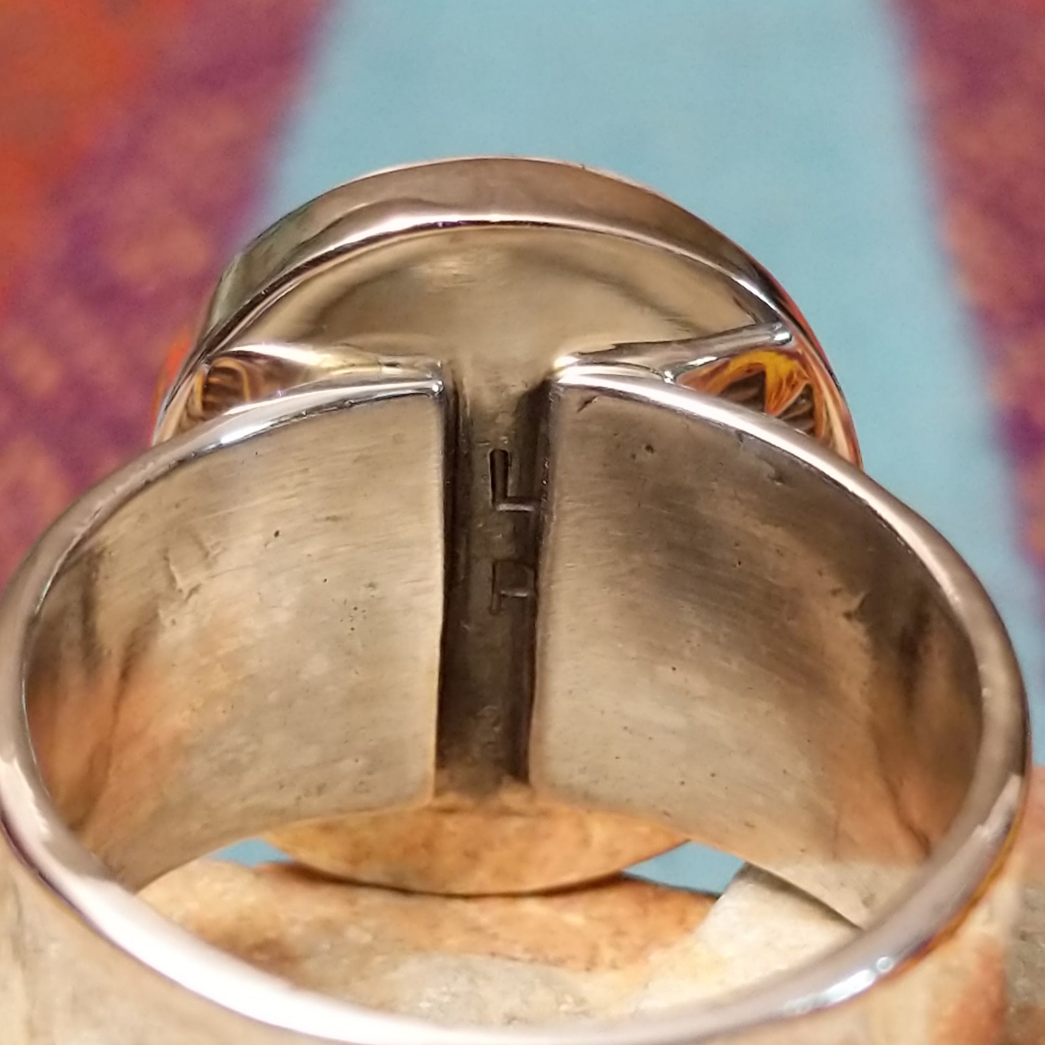 Round White Buffalo Ring by L.P. featuring a large creamy white cabochon with natural black and gray matrix, set in a smooth silver bezel with a substantial detailed silver band; artisan stamp.