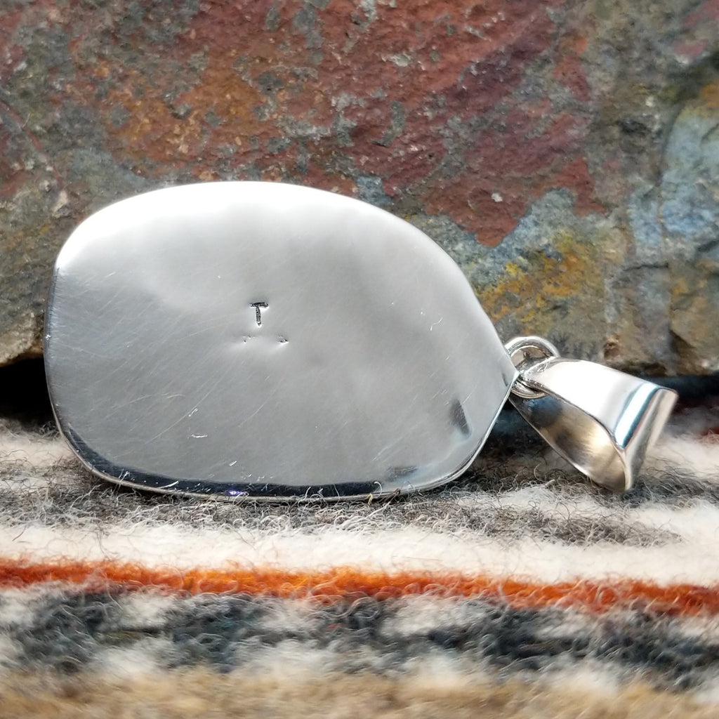 The back features the artisan's initial.