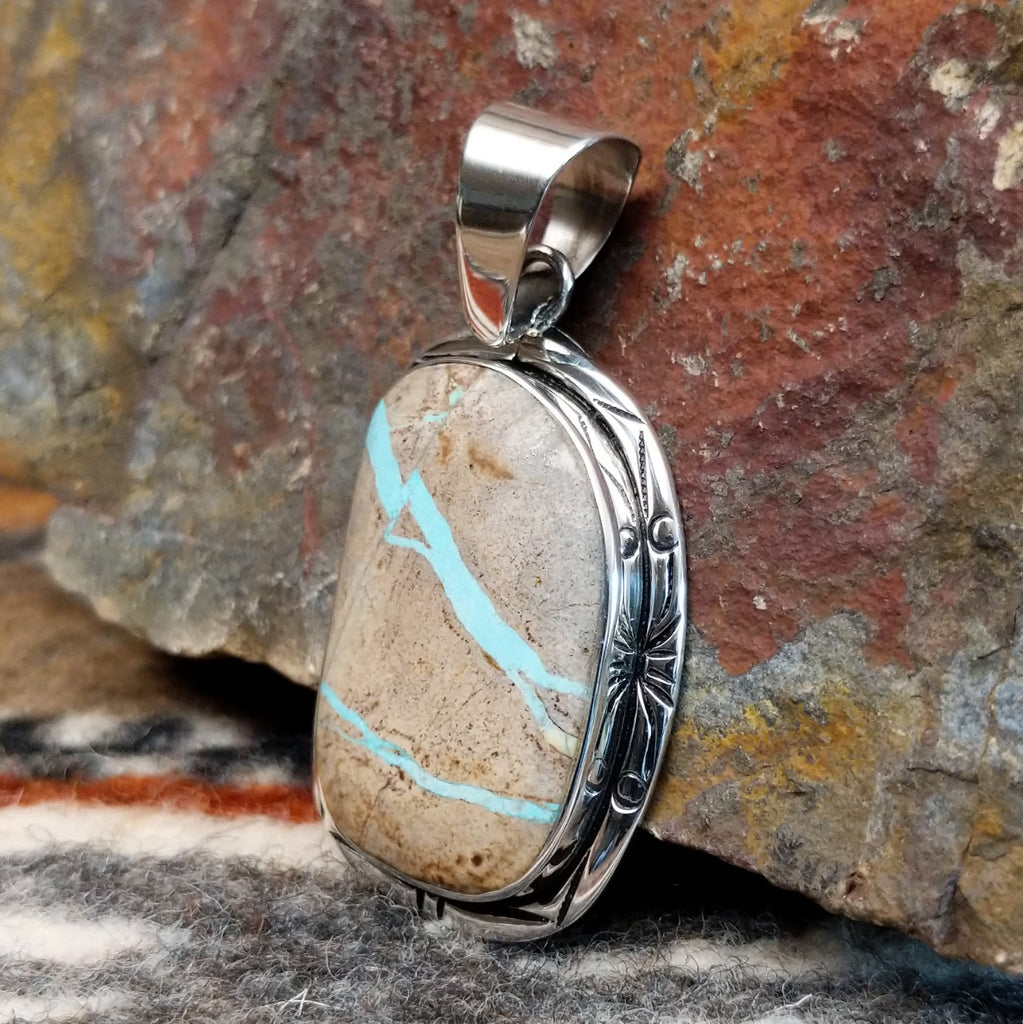 Sterling silver pendant with fine detailing and boulder turquoise set in the bezel.