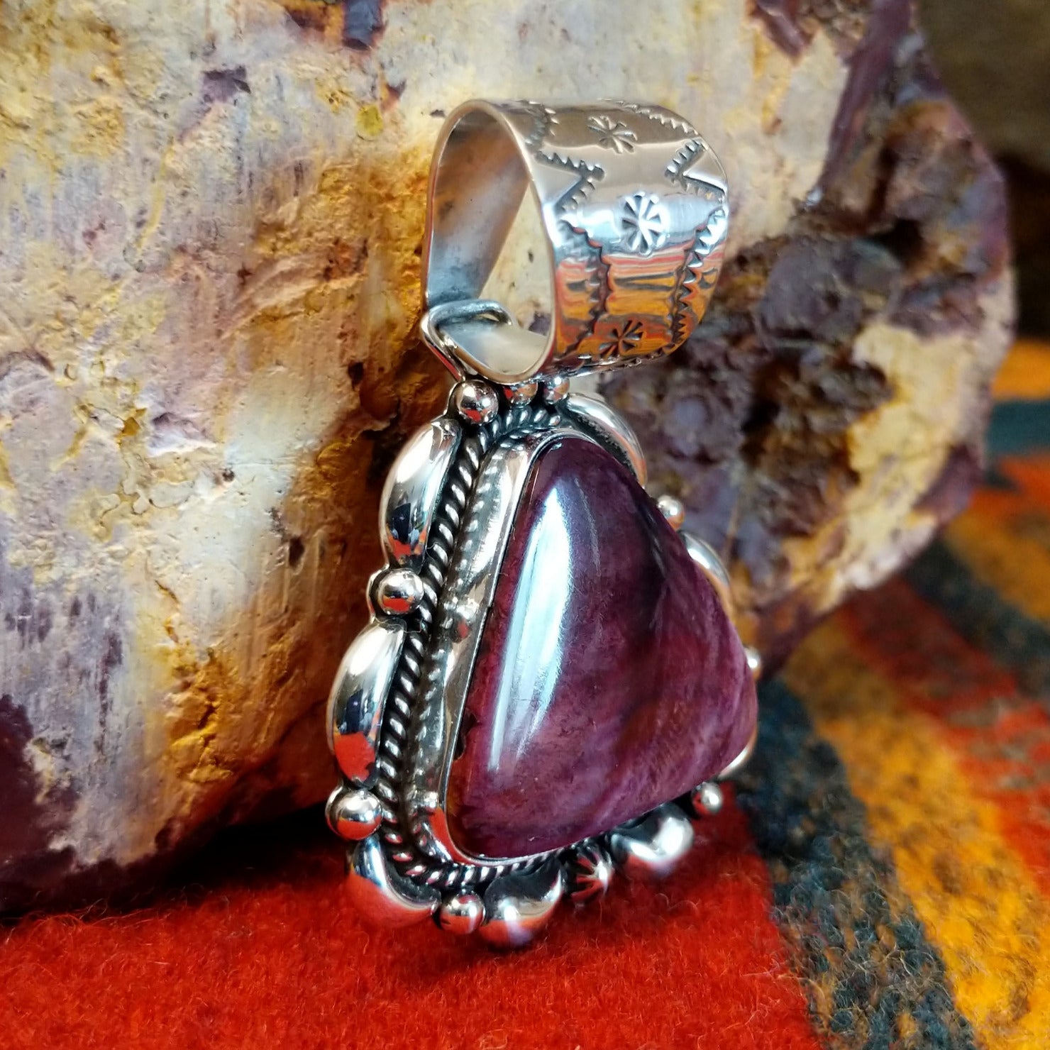 Triangular purple spiny oyster shell set in sterling silver with twisted rope accents, scalloped edges, and detailed dot work.