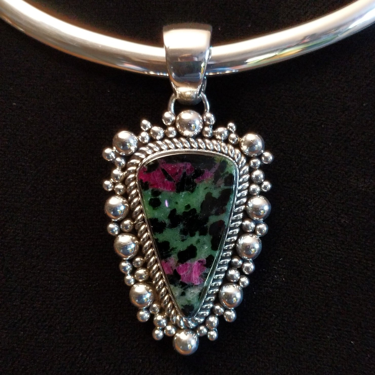 Ruby zoisite set in sterling silver bezels framed by dotted accents on both the earrings and pendant.