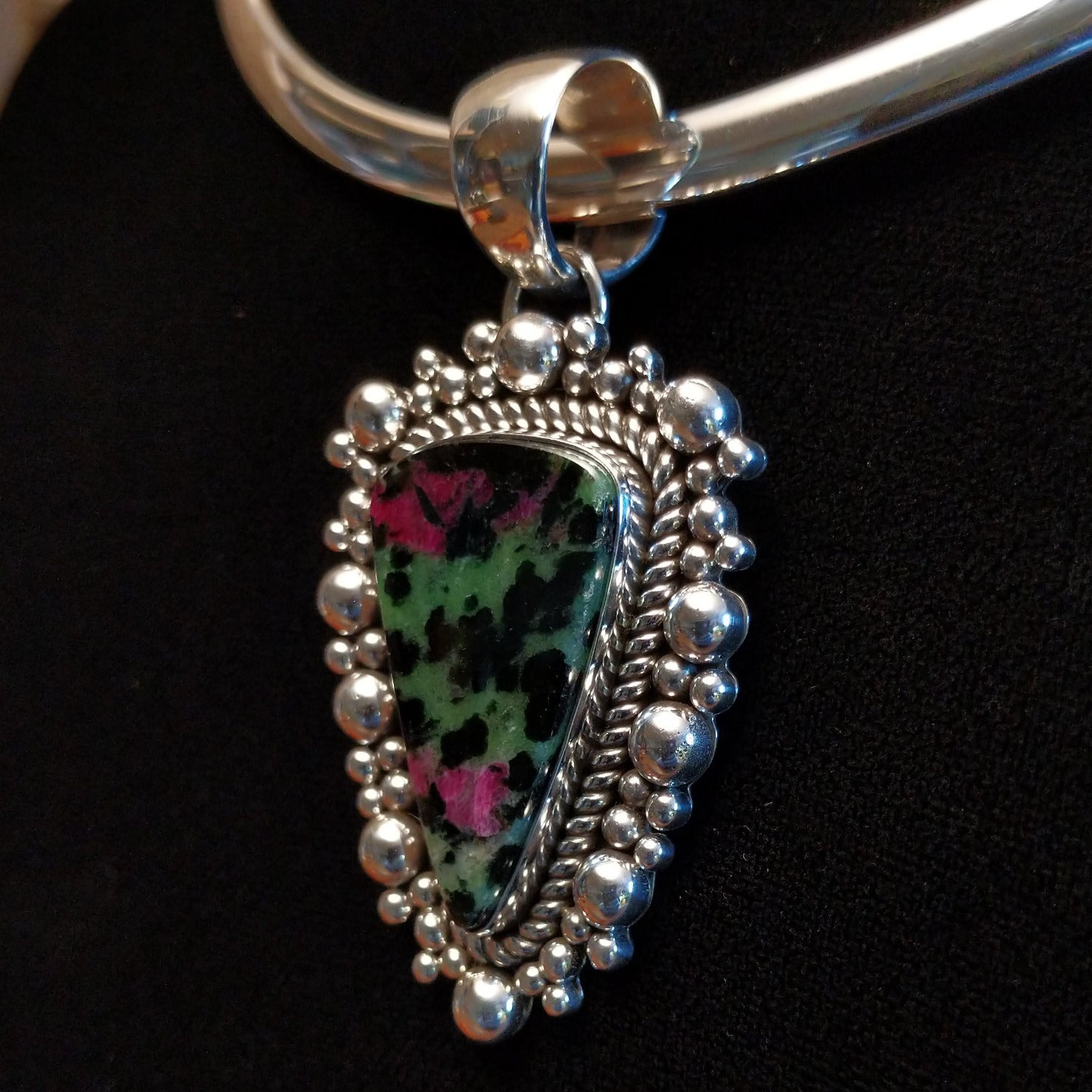 Ruby zoisite set in sterling silver bezels framed by dotted accents on both the earrings and pendant.