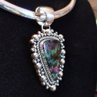 Ruby zoisite set in sterling silver bezels framed by dotted accents on both the earrings and pendant.