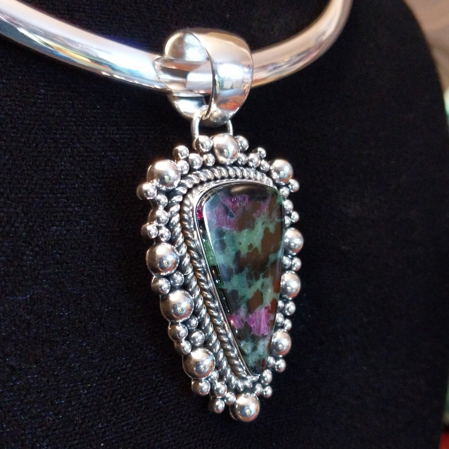 Ruby zoisite set in sterling silver bezels framed by dotted accents on both the earrings and pendant.