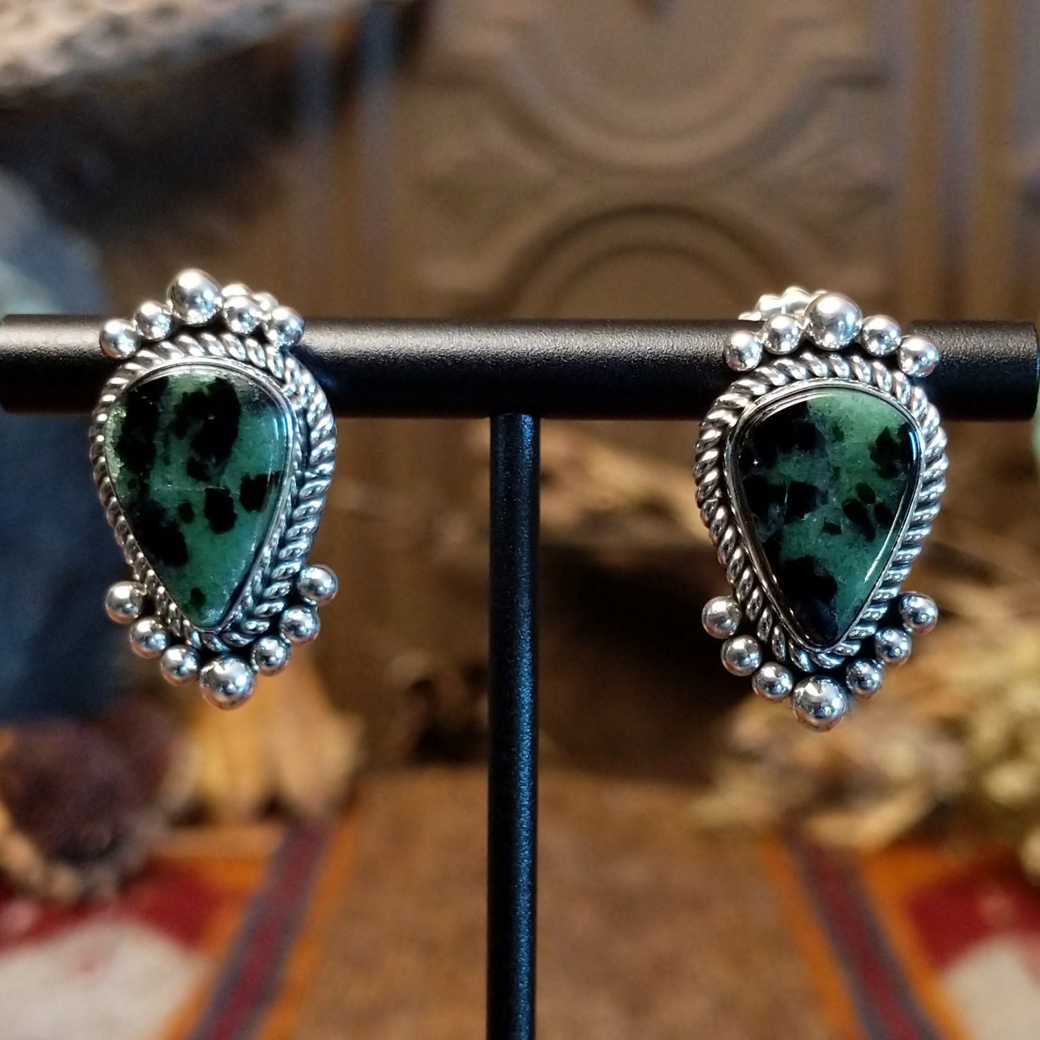 Ruby zoisite set in sterling silver bezels framed by dotted accents on both the earrings and pendant.
