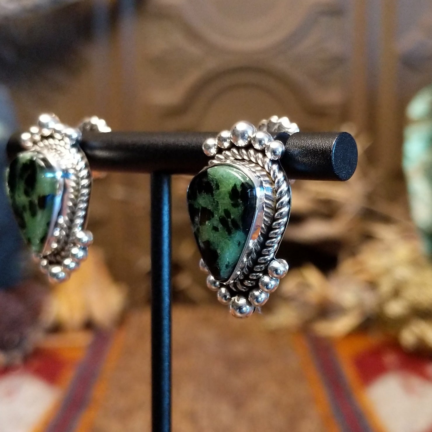Ruby zoisite set in sterling silver bezels framed by dotted accents on both the earrings and pendant.