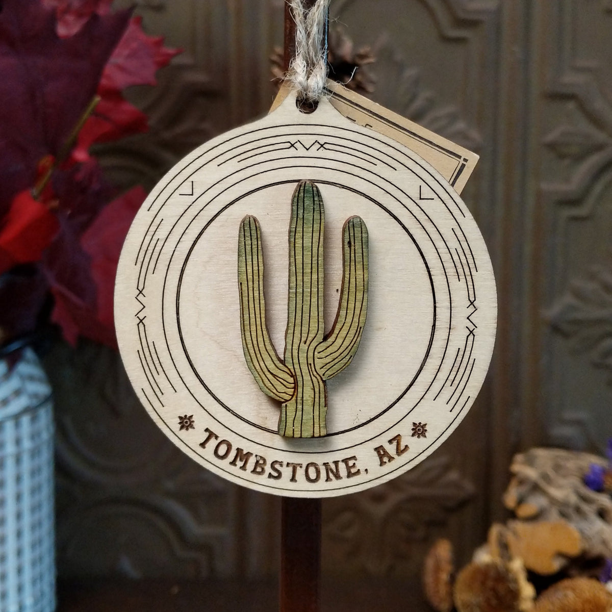 Saguaro Wood Ornament featuring a raised green cactus design, engraved circular wooden frame, “Tombstone, AZ” lettering, and natural twine hanging loop.