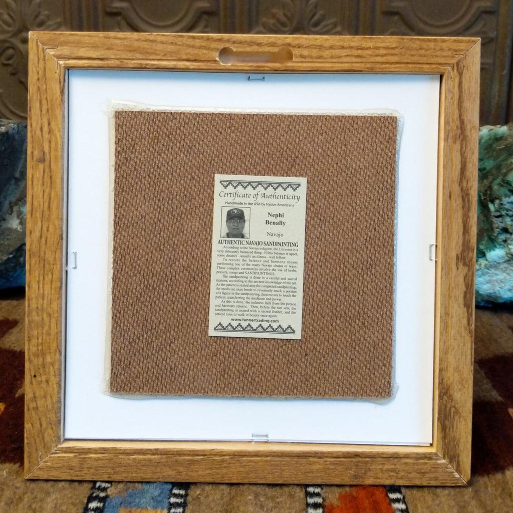 The back features the artisan's authentication tag and wooden frame with a place for a hook.