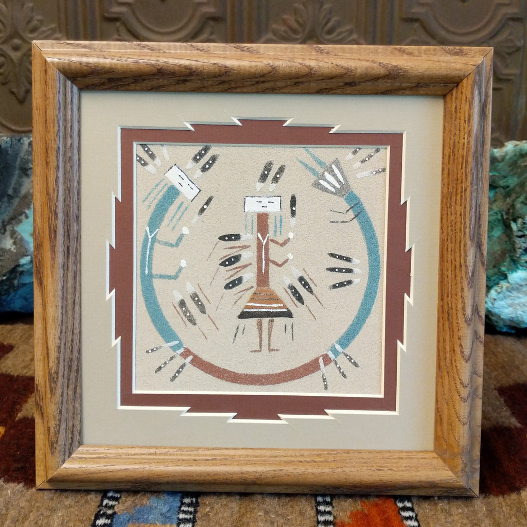 Multicolored sand creating a sand painting within a wooden frame.