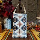 Sandstone Club Bag by Bamboo Trading featuring intricate Southwestern geometric beadwork in ivory, charcoal, slate blue, silver, and peach, with symmetrical diamond patterns, sparkling sequins, and a cream-colored shoulder strap.