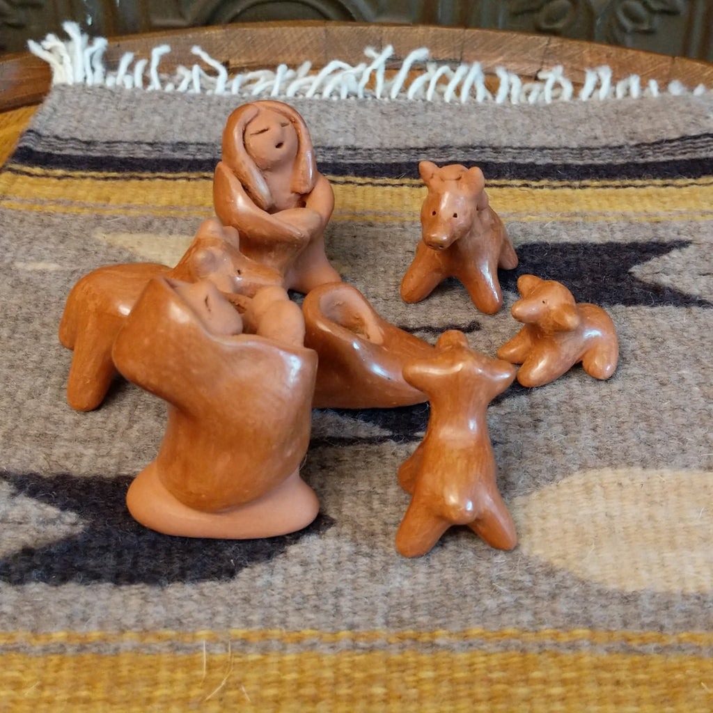 Clay sculpted into individual pieces of a nativity scene and glazed.