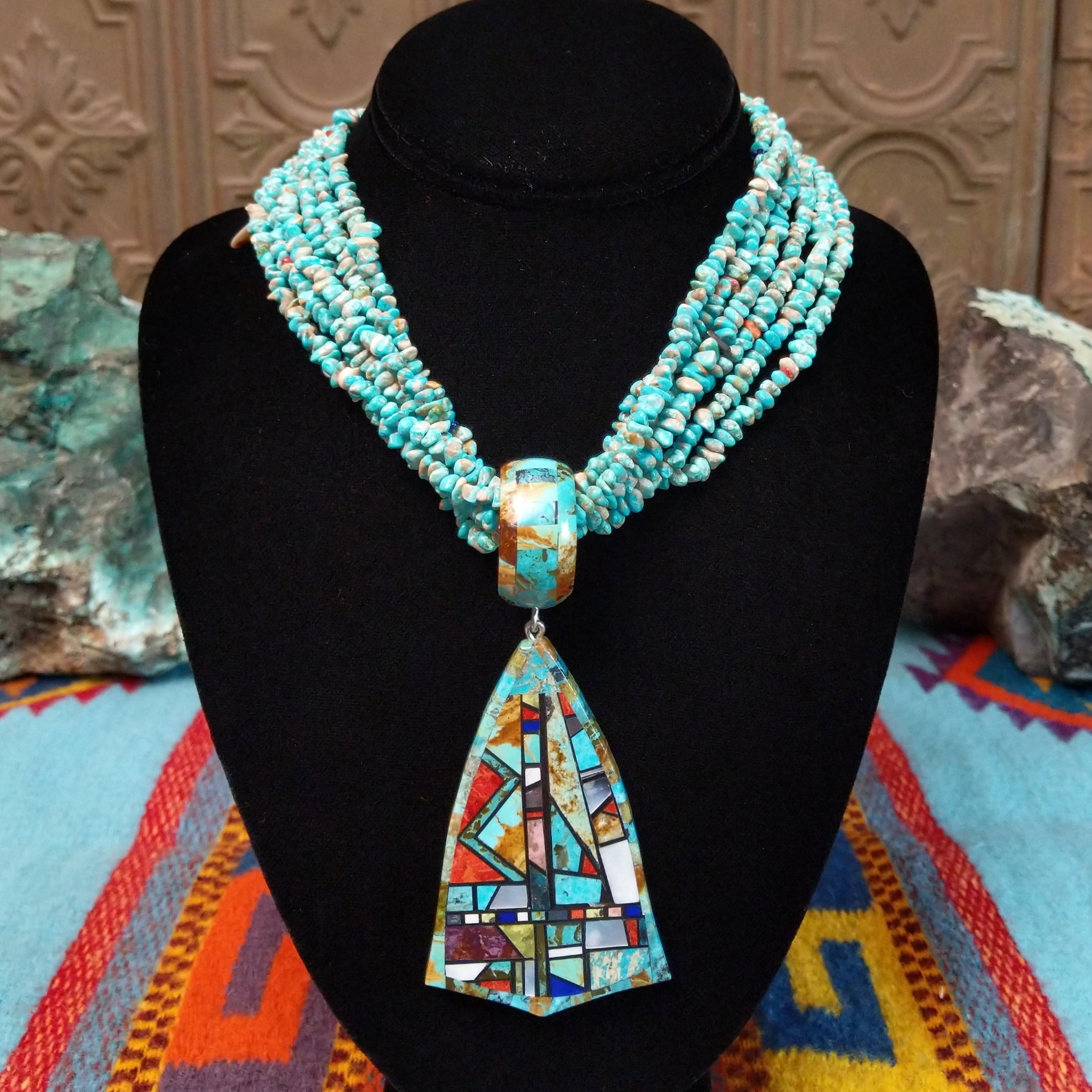 Multi-strand turquoise bead necklace with a large geometric multistone mosaic pendant