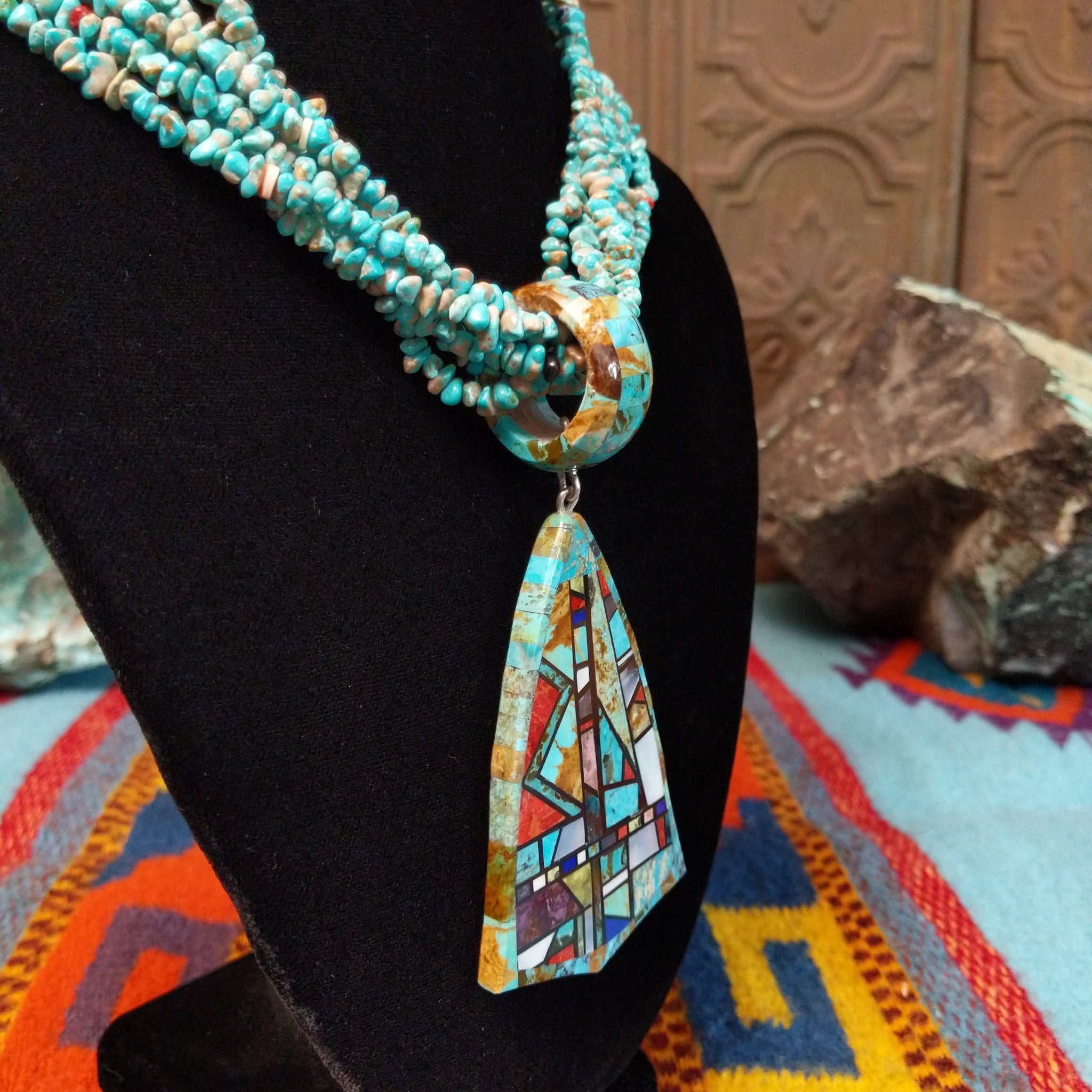 Multi-strand turquoise bead necklace with a large geometric multistone mosaic pendant