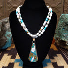 Sterling silver necklace with turquoise and white buffalo beaded along the chain and inlaid on the pendant.