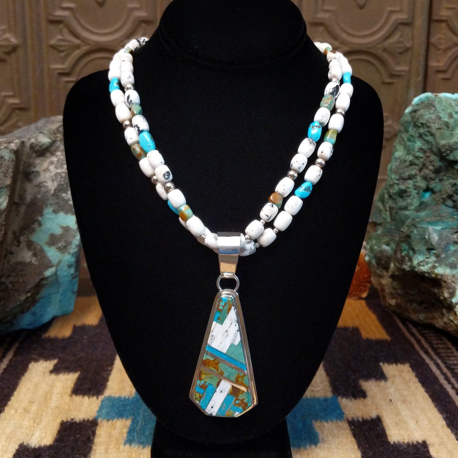 Sterling silver necklace with turquoise and white buffalo beaded along the chain and inlaid on the pendant.