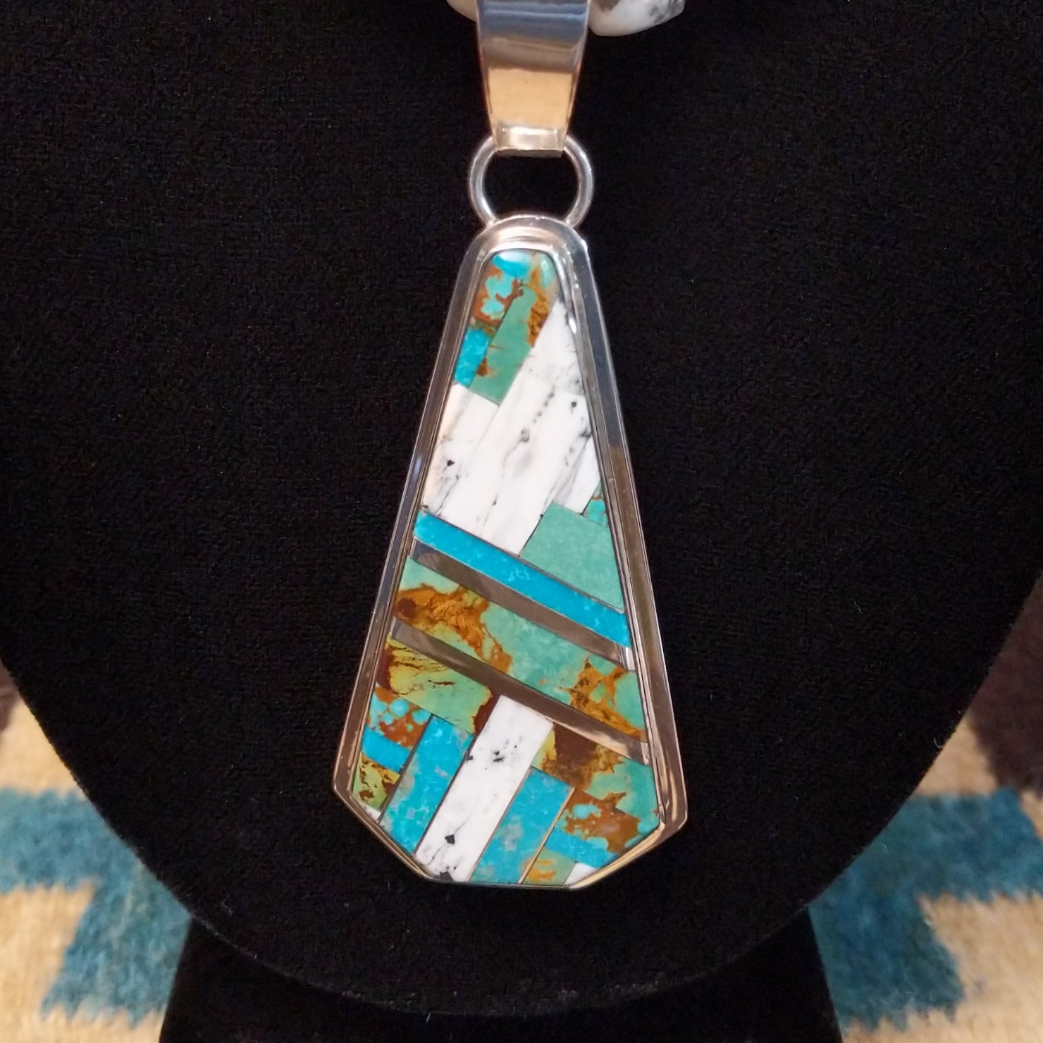 Sterling silver necklace with turquoise and white buffalo beaded along the chain and inlaid on the pendant.
