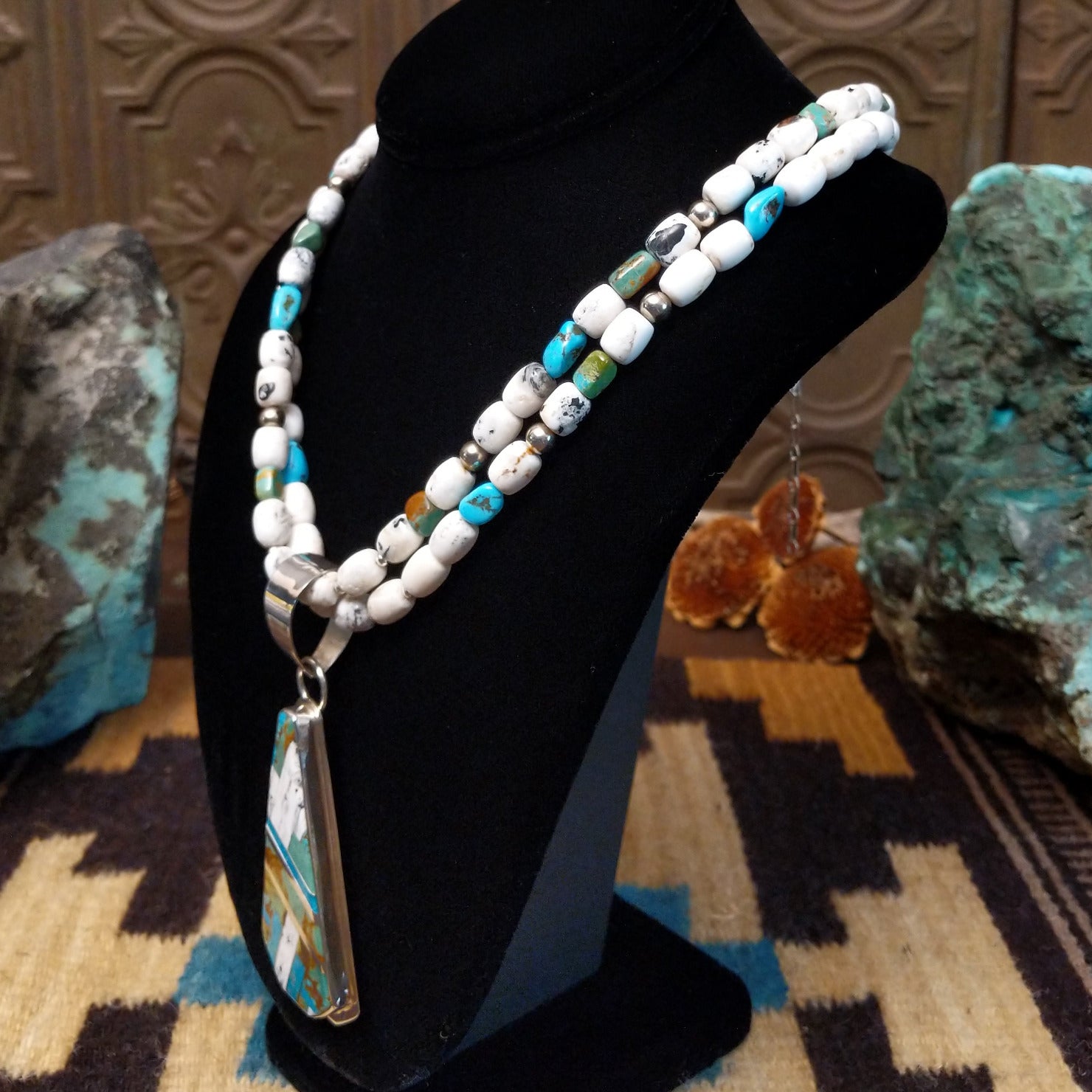 Sterling silver necklace with turquoise and white buffalo beaded along the chain and inlaid on the pendant.