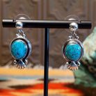 Sterling silver earrings with Kingman turquoise set in the raised bezels, framed by the scalloped design.