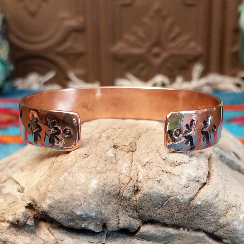 Copper and sterling silver cuff with stamped shrub design on the silver.