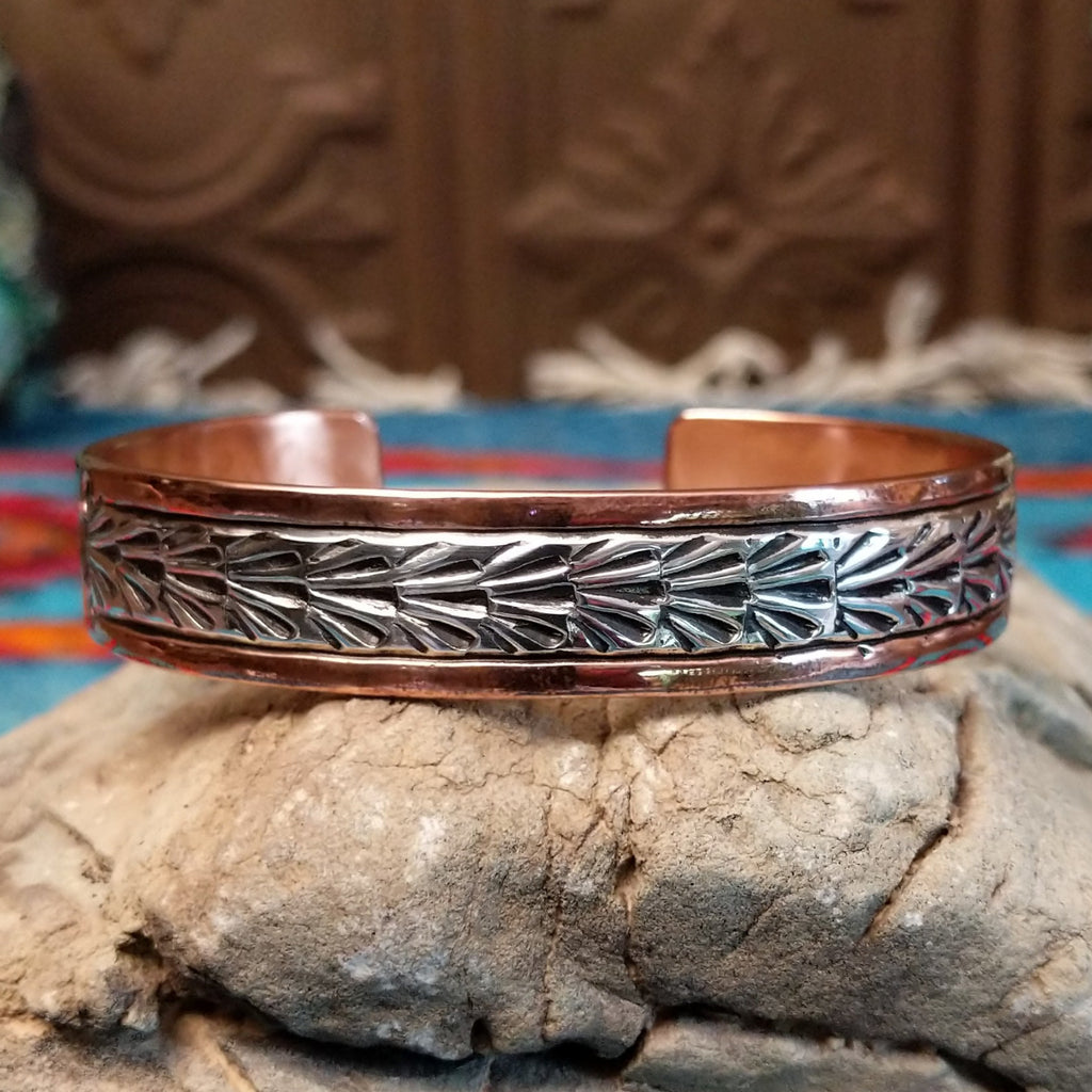 Copper and sterling silver cuff with stamped shrub design on the silver.