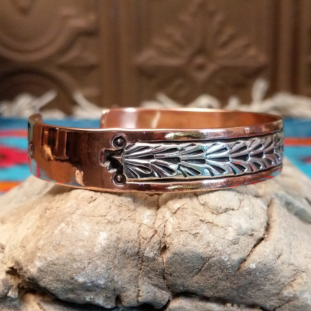 Copper and sterling silver cuff with stamped shrub design on the silver.