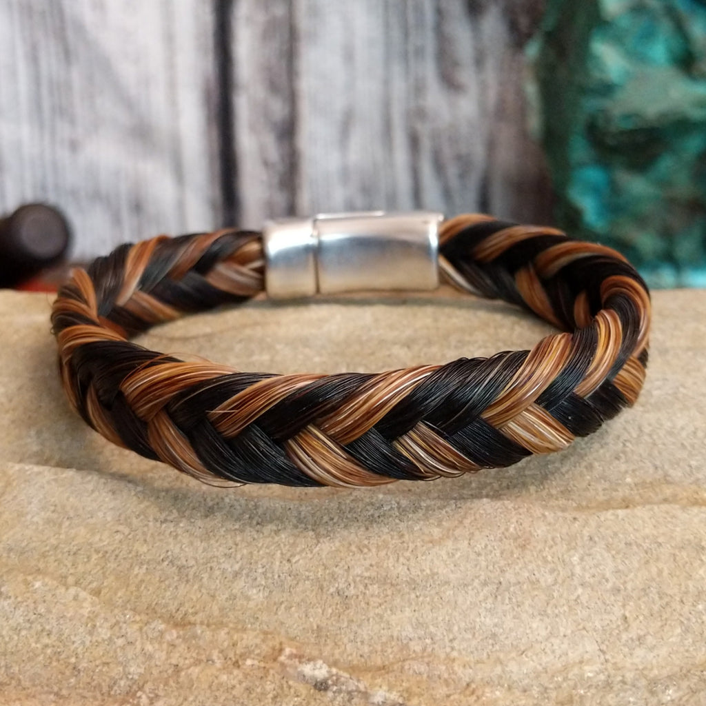 A braided multi-toned horsehair bracelet in black, brown, and tan, secured with a magnetic clasp.