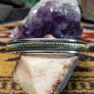 Sterling silver and 14k gold cuff by Bruce Morgan with curved stamped center design.