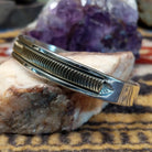 Sterling silver and 14k gold cuff by Bruce Morgan with curved stamped center design.