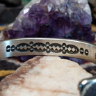 Detailed view of decorative stamp pattern along the inside of the cuff.